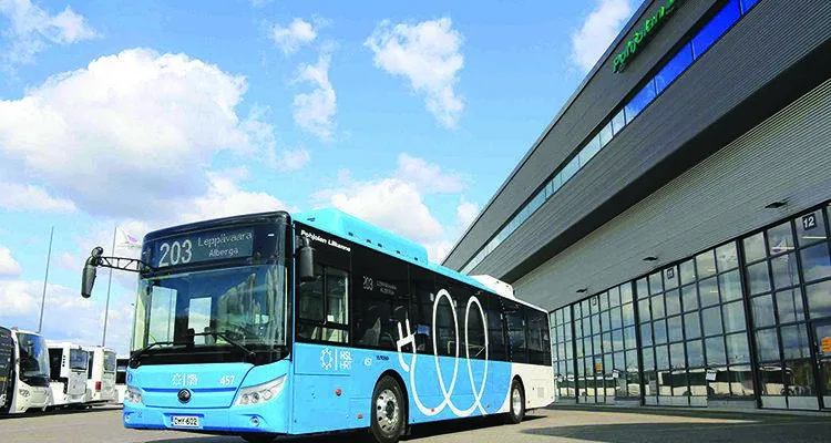 A blue bus parked outside a buildingDescription automatically generated