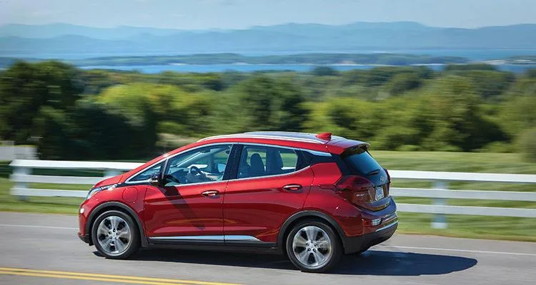 A red car on a roadDescription automatically generated