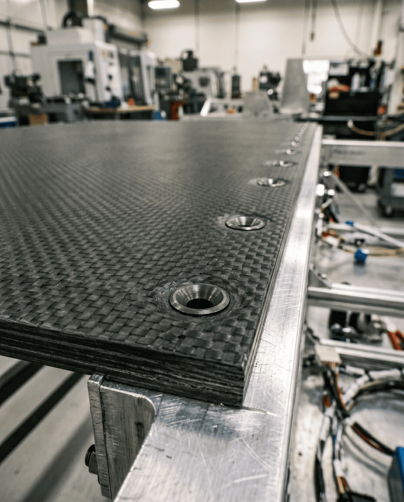 Countersunk fastener holes drilled through a CFRP laminate panel joined to an aluminium subframe