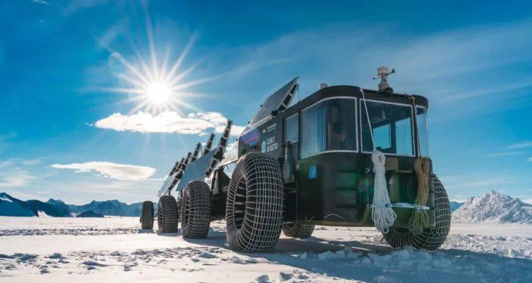 A vehicle with large wheels on snowDescription automatically generated