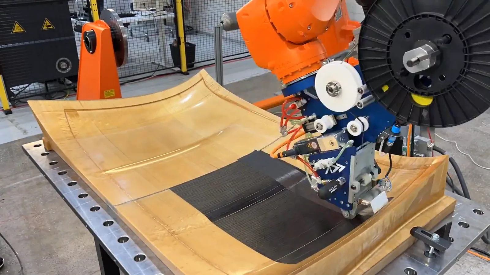 Addcomposites AFP-XS depositing carbon fiber tow on a curved mold