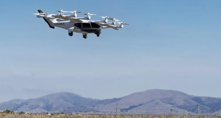 A drone flying over a fieldDescription automatically generated