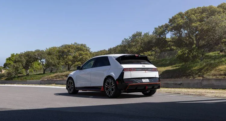 A white car on a roadDescription automatically generated