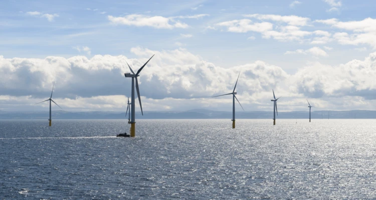 A group of wind turbines in the oceanDescription automatically generated