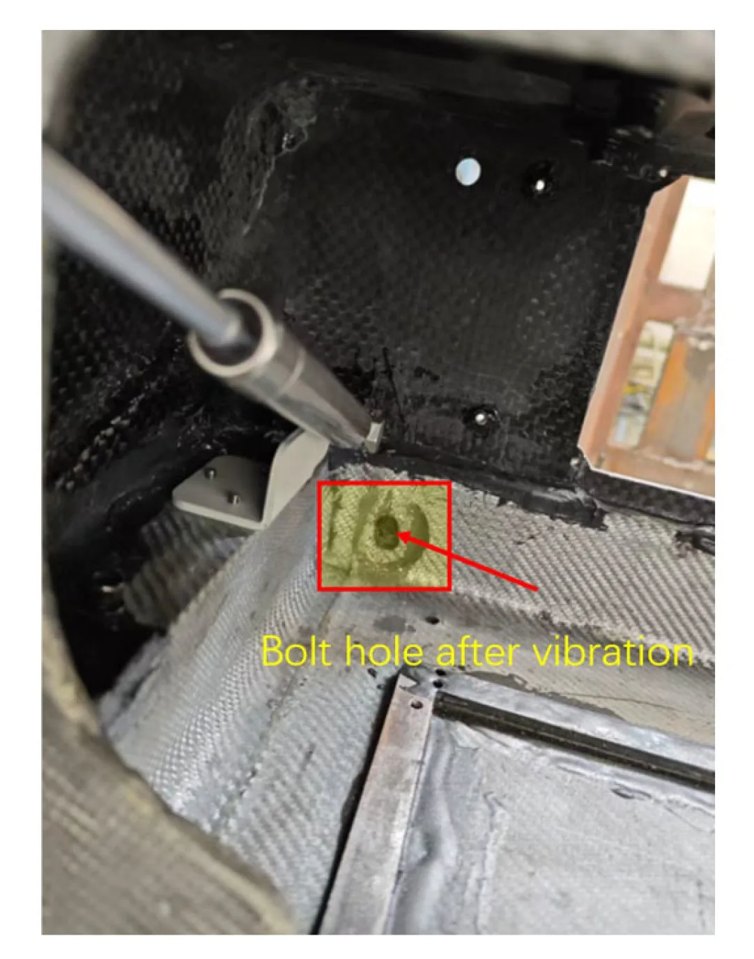 Post-test inspection inside the frame, with the elongated bolt hole at the display bracket attachment highlighted where the metal meets the laminate.