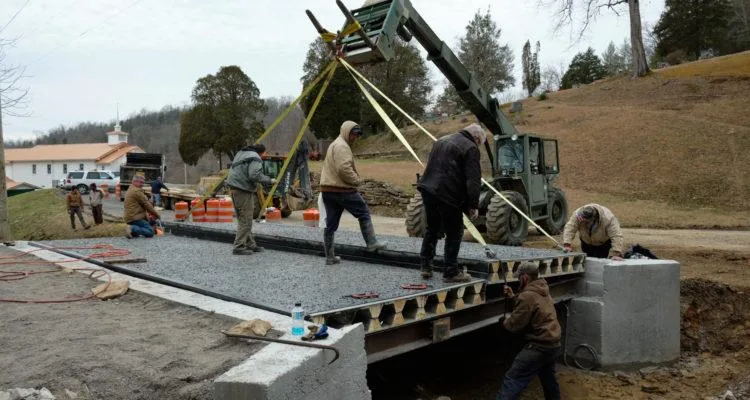 A group of men working on a bridgeDescription automatically generated