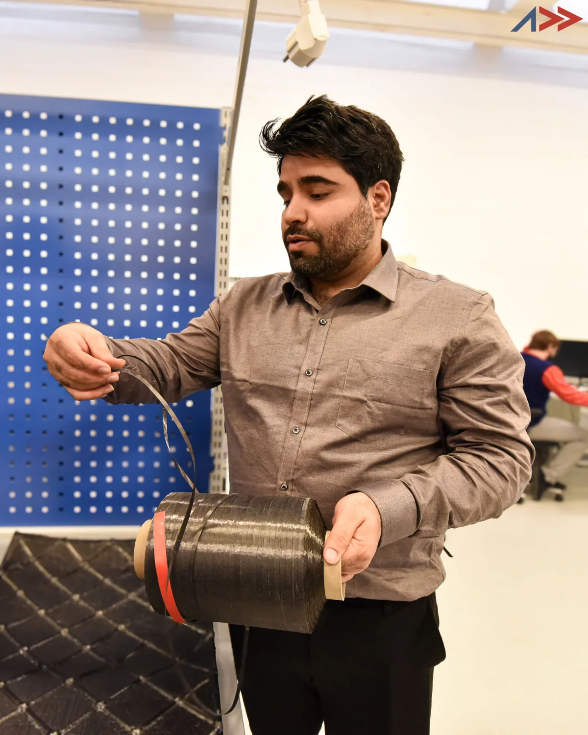 A spool of dry carbon fiber tape in the Addcomposites lab.
