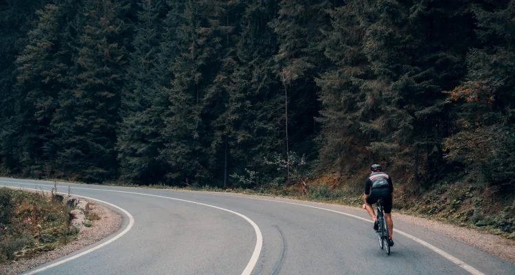 A person riding a bicycle on a roadDescription automatically generated