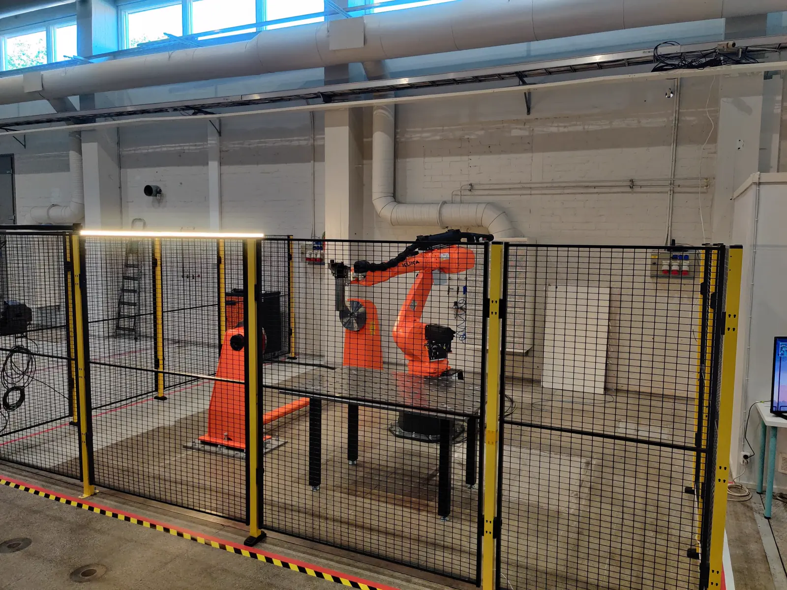 A complete AddCell installation with industrial robot, tooling and safety enclosure