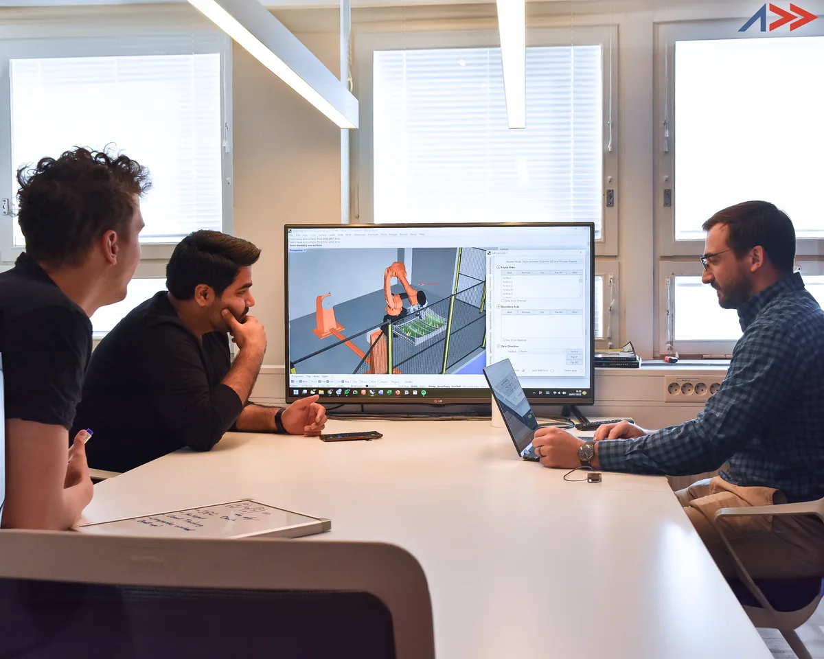 Addcomposites engineers reviewing a robot-cell simulation in AddPath